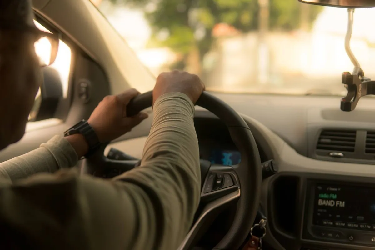 Les mains d’un pilote bénévole sur le volant de son véhicule